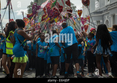Londres, Royaume-Uni. 24 août, 2014. Revelers en bleu t-shirts transportant du défilé de coeurs 2014 Notting Hill Carnival, children's day : Crédit photographique à vue/Alamy Live News Banque D'Images
