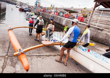 L'équipe d'aviron de six hommes le lancement d'une pirogue à Playa San Juan, Tenerife, Canaries, Espagne. Banque D'Images