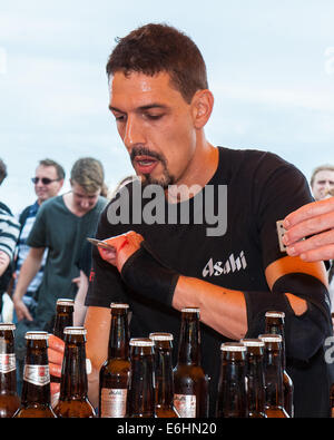 Brighton, UK. 24 août, 2014. Bloodies knuckles ne pas le ralentir. François Monin, sous-chef de bar à Lucky Voice, Brighton, établit un nouveau record du monde de vitesse d'ouverture de 2000 bouteilles de bière. Il a pulvérisé le record mondial Guinness actuel qui s'élevait à 28 minutes 11secondes de près de 4 minutes, l'ouverture de bouteilles 2030 en 24 minutes 37 secondes. L'événement s'est tenu à l'Azure bar et restaurant sur la plage de Brighton entre la jetée de Brighton et la roue de Brighton et a été parrainé par Asahi beer. Credit : Julia Claxton/Alamy Live News Banque D'Images