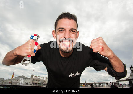 Brighton, UK. 24 août, 2014. On fête le nouveau record du monde -François Monin, sous-chef de bar à Lucky Voice, Brighton, établit un nouveau record du monde de vitesse d'ouverture de 2000 bouteilles de bière. Il a pulvérisé le record mondial Guinness actuel qui s'élevait à 28 minutes 11secondes de près de 4 minutes, l'ouverture de bouteilles 2030 en 24 minutes 37 secondes. L'événement s'est tenu à l'Azure bar et restaurant sur la plage de Brighton entre la jetée de Brighton et la roue de Brighton et a été parrainé par Asahi beer. Credit : Julia Claxton/Alamy Live News Banque D'Images