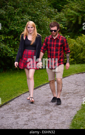 Old Westbury, New York, États-Unis - 23 août 2014 - Un garçon et fille porter le rouge et le noir des tenues à carreaux tartan marche le long d'un chemin de galets à la 54e Annual Long Island Festival écossais et les Jeux des Highlands, co-organisé par L. I. clan écossais MacDuff, at Old Westbury Gardens. Banque D'Images