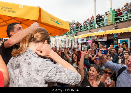 Brighton, UK. 24 août, 2014. On fête le nouveau record du monde -François Monin, sous-chef de bar à Lucky Voice, Brighton, établit un nouveau record du monde de vitesse d'ouverture de 2000 bouteilles de bière. Il a pulvérisé le record mondial Guinness actuel qui s'élevait à 28 minutes 11secondes de près de 4 minutes, l'ouverture de bouteilles 2030 en 24 minutes 37 secondes. L'événement s'est tenu à l'Azure bar et restaurant sur la plage de Brighton entre la jetée de Brighton et la roue de Brighton et a été parrainé par Asahi beer. Credit : Julia Claxton/Alamy Live News Banque D'Images