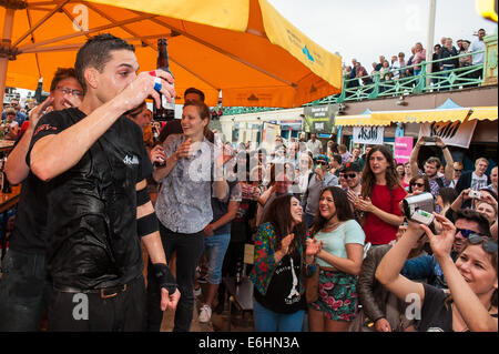 Brighton, UK. 24 août, 2014. On fête le nouveau record du monde -François Monin, sous-chef de bar à Lucky Voice, Brighton, établit un nouveau record du monde de vitesse d'ouverture de 2000 bouteilles de bière. Il a pulvérisé le record mondial Guinness actuel qui s'élevait à 28 minutes 11secondes de près de 4 minutes, l'ouverture de bouteilles 2030 en 24 minutes 37 secondes. L'événement s'est tenu à l'Azure bar et restaurant sur la plage de Brighton entre la jetée de Brighton et la roue de Brighton et a été parrainé par Asahi beer. Credit : Julia Claxton/Alamy Live News Banque D'Images