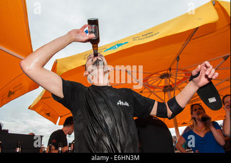 Brighton, UK. 24 août, 2014. On fête le nouveau record du monde -François Monin, sous-chef de bar à Lucky Voice, Brighton, établit un nouveau record du monde de vitesse d'ouverture de 2000 bouteilles de bière. Il a pulvérisé le record mondial Guinness actuel qui s'élevait à 28 minutes 11secondes de près de 4 minutes, l'ouverture de bouteilles 2030 en 24 minutes 37 secondes. L'événement s'est tenu à l'Azure bar et restaurant sur la plage de Brighton entre la jetée de Brighton et la roue de Brighton et a été parrainé par Asahi beer. Credit : Julia Claxton/Alamy Live News Banque D'Images