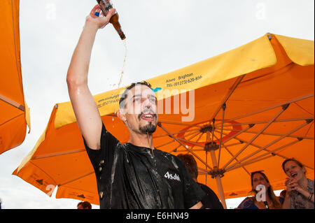 Brighton, UK. 24 août, 2014. On fête le nouveau record du monde -François Monin, sous-chef de bar à Lucky Voice, Brighton, établit un nouveau record du monde de vitesse d'ouverture de 2000 bouteilles de bière. Il a pulvérisé le record mondial Guinness actuel qui s'élevait à 28 minutes 11secondes de près de 4 minutes, l'ouverture de bouteilles 2030 en 24 minutes 37 secondes. L'événement s'est tenu à l'Azure bar et restaurant sur la plage de Brighton entre la jetée de Brighton et la roue de Brighton et a été parrainé par Asahi beer. Credit : Julia Claxton/Alamy Live News Banque D'Images