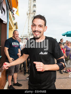 Brighton, UK. 24 août, 2014. On fête le nouveau record du monde -François Monin, sous-chef de bar à Lucky Voice, Brighton, établit un nouveau record du monde de vitesse d'ouverture de 2000 bouteilles de bière. Il a pulvérisé le record mondial Guinness actuel qui s'élevait à 28 minutes 11secondes de près de 4 minutes, l'ouverture de bouteilles 2030 en 24 minutes 37 secondes. L'événement s'est tenu à l'Azure bar et restaurant sur la plage de Brighton entre la jetée de Brighton et la roue de Brighton et a été parrainé par Asahi beer. Credit : Julia Claxton/Alamy Live News Banque D'Images