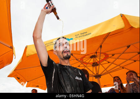 Brighton, UK. 24 août, 2014. On fête le nouveau record du monde -François Monin, sous-chef de bar à Lucky Voice, Brighton, établit un nouveau record du monde de vitesse d'ouverture de 2000 bouteilles de bière. Il a pulvérisé le record mondial Guinness actuel qui s'élevait à 28 minutes 11secondes de près de 4 minutes, l'ouverture de bouteilles 2030 en 24 minutes 37 secondes. L'événement s'est tenu à l'Azure bar et restaurant sur la plage de Brighton entre la jetée de Brighton et la roue de Brighton et a été parrainé par Asahi beer. Credit : Julia Claxton/Alamy Live News Banque D'Images