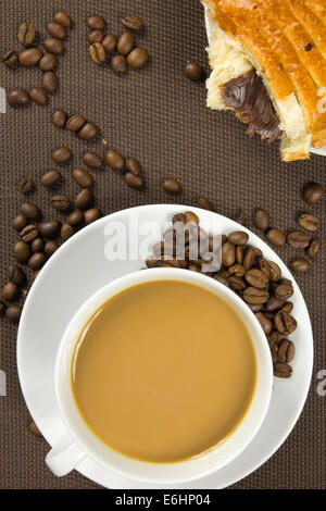 Tasse de café et en français pain au chocolat sur fond brun Banque D'Images