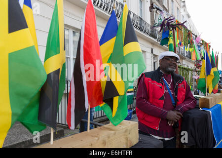 Man selling Caraïbes drapeaux et de souvenirs à un décrochage dans le carnaval de Notting Hill, Londres Banque D'Images