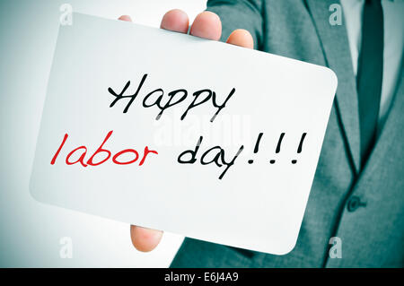 Un homme portant un costume montrant une pancarte à la fête du travail heureux texte écrit en c Banque D'Images