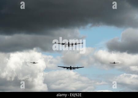 Bombardier Lancaster, Spitfire et les avions volent passé contre rainclouds orageux à Odyssée militaire show, Detling, Kent, Angleterre Banque D'Images