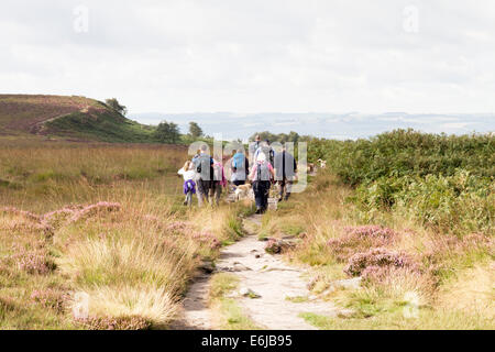 Un groupe de randonneurs marchant le long Froggatt Edge dans le Derbyshire Peak District Banque D'Images