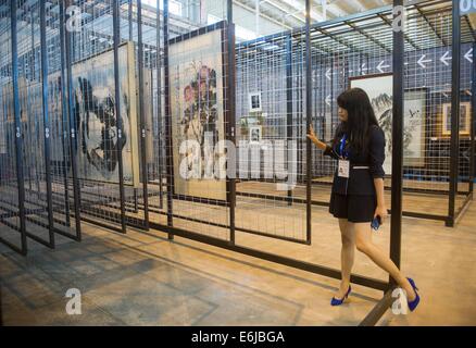 Beijing, Chine. 25 août, 2014. Un membre du personnel organise des œuvres à la Base nationale de commerce culturel international (Beijing) à Beijing, capitale de Chine, le 25 août 2014. La Base nationale de commerce culturel international ouvert ici lundi. Credit : Luo Xiaoguang/Xinhua/Alamy Live News Banque D'Images