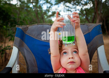 Big Blue Eyed Girl l'étude d'un green fizzy drink Banque D'Images