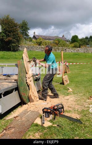 L'homme de faire une sculpture à la tronçonneuse d'un hibou dans Carmarthenshire Wales Cymru UK GO Banque D'Images