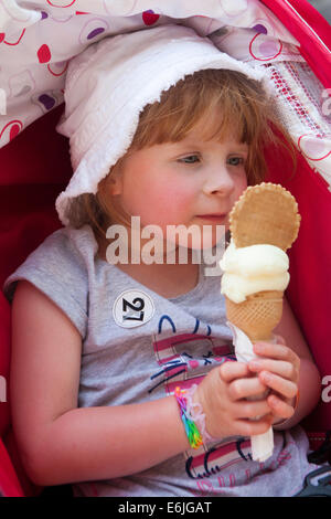 Quatre ans girl holding glace vanille avec biscuit Banque D'Images