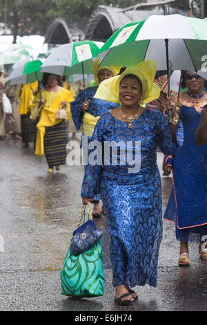 Londres, Royaume-Uni. 25 août 2014. Certains participants y la parade in Style - avec l'aide de grands parasols. Les visiteurs et les participants du carnaval de Notting Hill 2014 Bank Holiday parade lundi s'est imbibé de leur peau, mais la météo n'a pu refroidir les fêtards esprit - bien qu'un grand nombre de spectateurs sont restés à l'écart. Photo : Nick Savage/Alamy Live News Banque D'Images