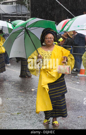 Londres, Royaume-Uni. 25 août 2014. Certains participants y la parade in Style - avec l'aide de grands parasols. Les visiteurs et les participants du carnaval de Notting Hill 2014 Bank Holiday parade lundi s'est imbibé de leur peau, mais la météo n'a pu refroidir les fêtards esprit - bien qu'un grand nombre de spectateurs sont restés à l'écart. Photo : Nick Savage/Alamy Live News Banque D'Images