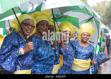 Londres, Royaume-Uni. 25 août 2014. Certains participants y la parade in Style - avec l'aide de grands parasols. Les visiteurs et les participants du carnaval de Notting Hill 2014 Bank Holiday parade lundi s'est imbibé de leur peau, mais la météo n'a pu refroidir les fêtards esprit - bien qu'un grand nombre de spectateurs sont restés à l'écart. Photo : Nick Savage/Alamy Live News Banque D'Images