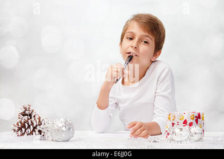 Boy écrit une lettre au Père Noël. Banque D'Images