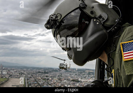 Le sergent de l'US Air Force. Michael Wright, 459e Escadron de transport aérien Huey UH-1N chef d'équipage portant un bouclier maxillo-faciale, des montres pour les obstacles au décollage pour une mission de formation le 12 août 2014 à Tokyo, Japon. Banque D'Images