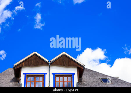 Maison rustique, ciel bleu et petit cluods Banque D'Images