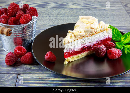 Gâteau à la framboise avec de la meringue dessus disposés sur une table en bois Banque D'Images