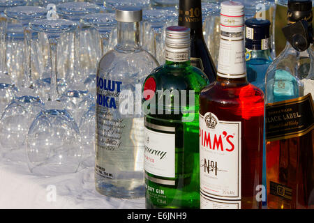 Diverses bouteilles d'alcool et des verres à vin renversés sur un dessus de table Banque D'Images