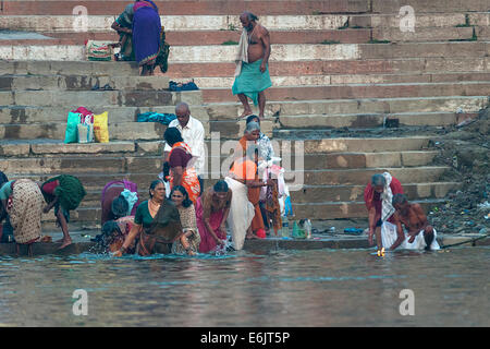 L'Inde Varanasi - 27 Février 2011 : Groupe de femmes prenant un bain rituel hindou à Ganges River tôt le matin au lever du soleil. Banque D'Images