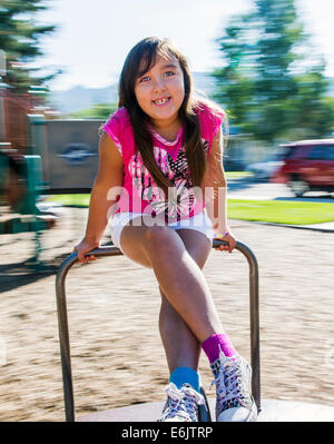 Photographie d'été de sept ans, fille, sur une aire de merry-go-round Banque D'Images