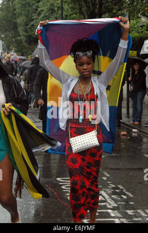 Londres, Royaume-Uni, 25 août 2014, le Notting Hill Carnival 2014 parties dans la pluie. La pluie incessante n'a rien fait pour arrêter l'atmosphère de fête comme la plus grande manifestation de rue n'a pas tenu compte des conditions météorologiques et sourit c'est long. Credit : JOHNNY ARMSTEAD/Alamy Live News Banque D'Images