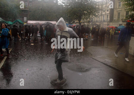 Londres, Royaume-Uni, 25 août 2014, le Notting Hill Carnival 2014 parties dans la pluie. La pluie incessante n'a rien fait pour arrêter l'atmosphère de fête comme la plus grande manifestation de rue n'a pas tenu compte des conditions météorologiques et sourit c'est long. Credit : JOHNNY ARMSTEAD/Alamy Live News Banque D'Images