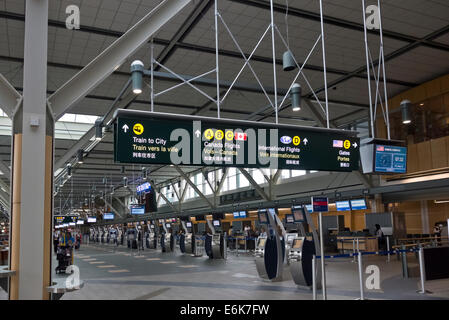 Les bornes d'enregistrement de vol dans la zone de départ de l'International de l'aéroport de Vancouver terminal. Panneaux pour portes et des transports Banque D'Images
