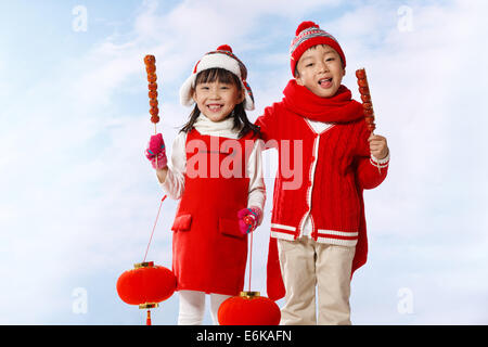 Boy and girl holding fruits confits Banque D'Images