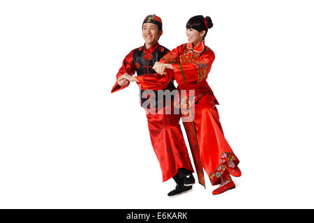Jeune couple habillés en vêtements traditionnels dancing célébrant le Nouvel An chinois Banque D'Images