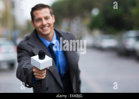 Close up portrait of young journalist microphone donnant Banque D'Images