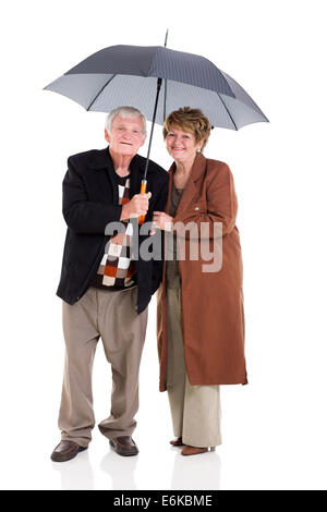 Joli couple de retraités sous un parapluie sur fond blanc Banque D'Images