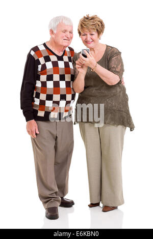 Joli couple using smart phone sur fond blanc Banque D'Images