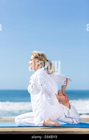 Middle aged woman practicing yoga outdoors Banque D'Images