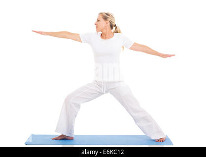 Femme d'âge moyen en bonne santé pratiquant le yoga exercice sur fond blanc Banque D'Images