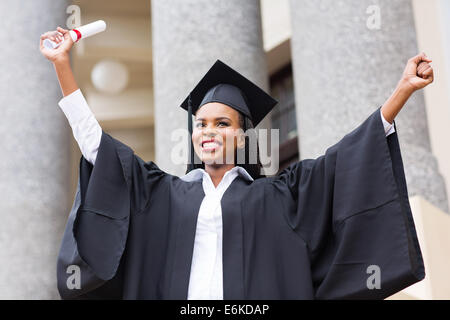 African American female graduate smiling standing in front of university building Banque D'Images