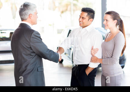 Vendeur d'âge moyen avec l'établissement de liaison happy young couple Banque D'Images