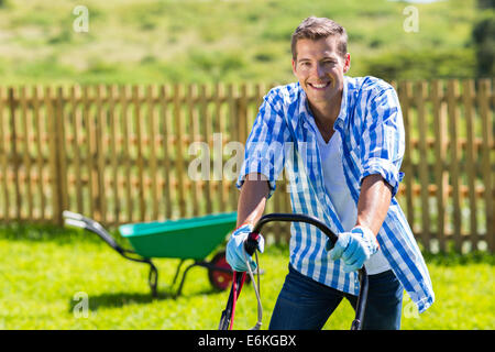 Homme heureux la pelouse à la maison jardin Banque D'Images