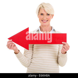 Jolie femme mature avec flèche de direction rouge sur fond blanc Banque D'Images