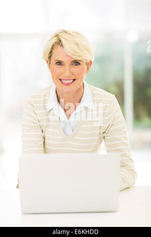 Smiling middle aged businesswoman with laptop Banque D'Images