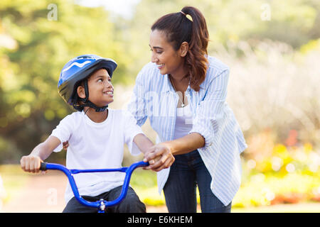 Mère amoureuse aider son fils mignon monter à vélo Banque D'Images