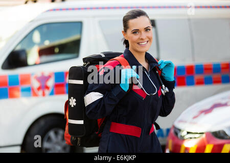 Belle Jeune femme transportant lifepack paramédic en face d'ambulance Banque D'Images