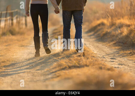 Young couple holding hands walking on automne chemin rural le matin Banque D'Images