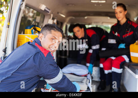 L'équipe de paramédics en tirant sur une ambulance civière Banque D'Images