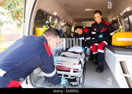 Le personnel paramédical de l'équipe de civière en tenant une ambulance Banque D'Images